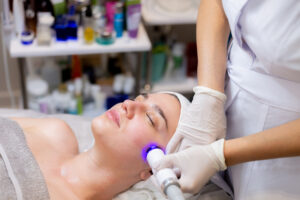 Person lying calmly in a full-body SpectraLight therapy bed at Light Therapy San Diego studio, soft blue and red glowing lights visible around them